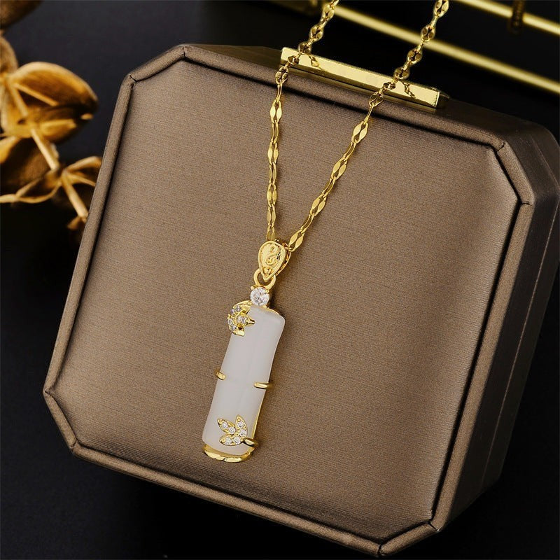 32lavender gold plated titanium steel necklace with white bamboo joint pendant and wavy chain, adorned with small crystals.